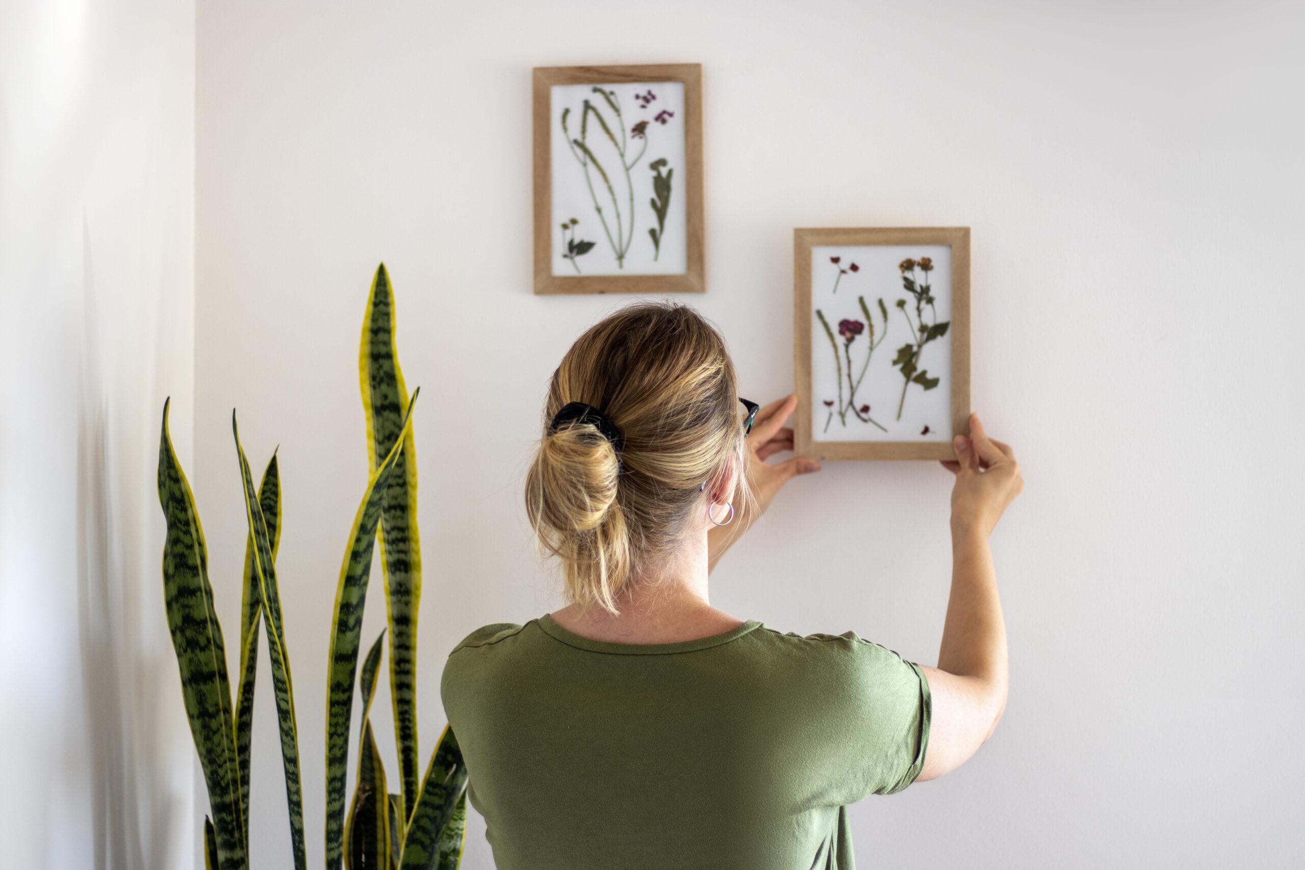 Woman hanging new art work on the wall